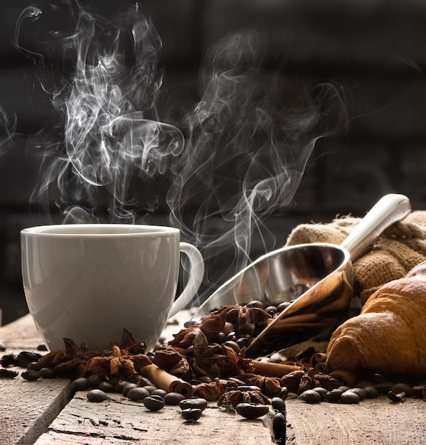 Café caliente y croissant en la mesa de madera antigua