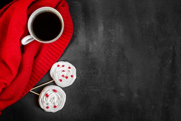 Café caliente fuerte y merengue francés en un fondo rojo. Concepto de bebidas, ocio y estilo de vida.