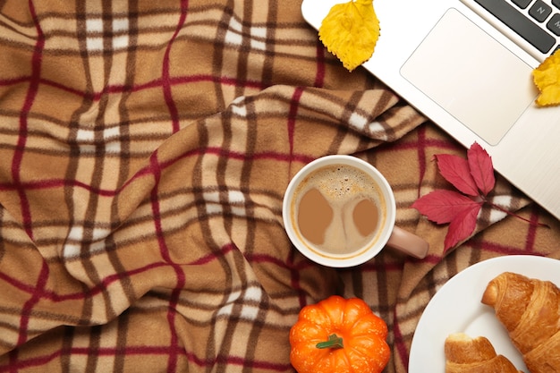 Café caliente y hojas de otoño con cuaderno a cuadros - concepto de relajación estacional. Vista superior