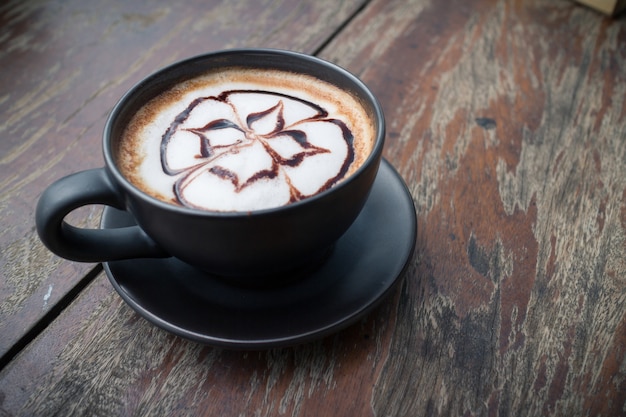 Café caliente con leche en espuma, arte en recreo por la tarde.