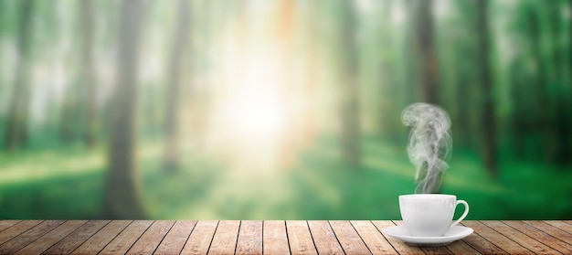 Café caliente en la mesa sobre un fondo de bosque primaveral