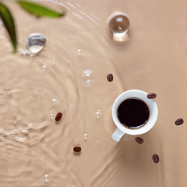 Café caliente salpicando en taza, agua y frijoles