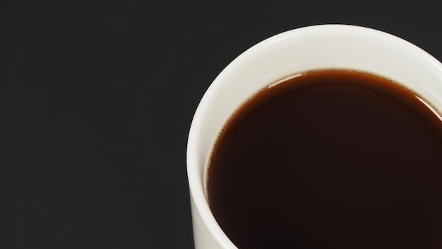 Café caliente en una taza blanca aislada en un suelo negro blanco.