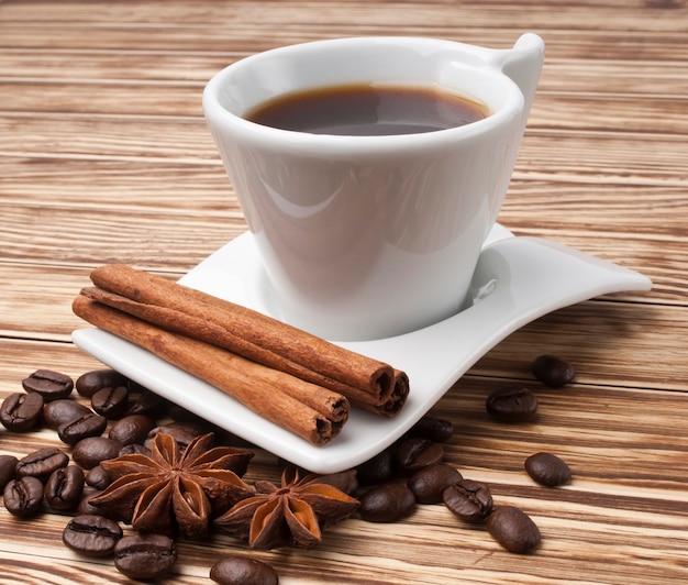 Café caliente en taza blanca sobre fondo de madera