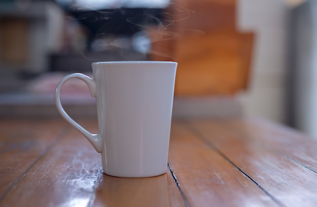 Café caliente en una taza blanca sobre la mesa.