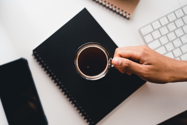 Café caliente en una taza en el escritorio de la computadora