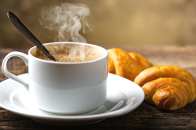 Café caliente en una taza sobre un fondo antiguo