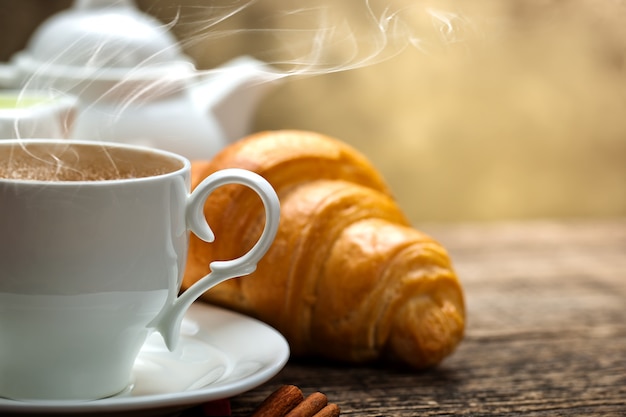 Café caliente en una taza sobre un fondo antiguo