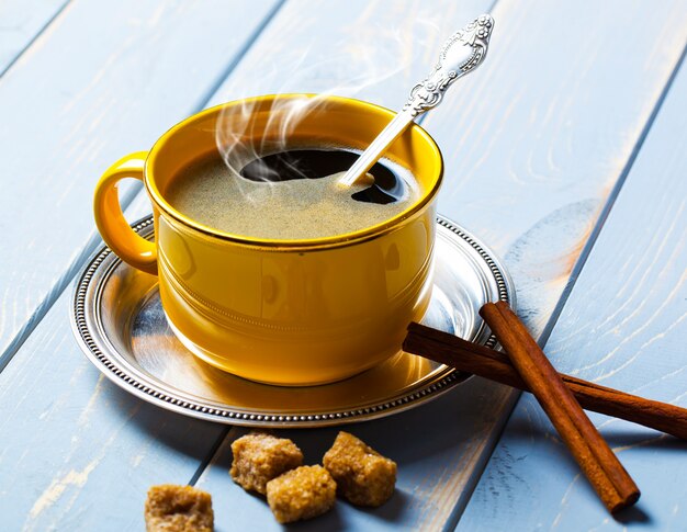 Café caliente en una taza sobre un fondo antiguo