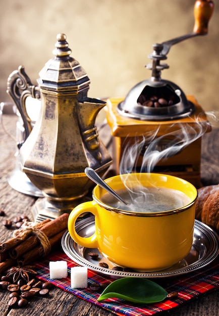 Café caliente en una taza sobre un fondo antiguo