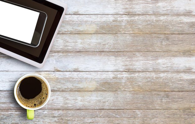 Café caliente en una taza verde sobre una mesa de madera antigua