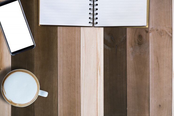 Foto café caliente, teléfono móvil y libro vacío en mesa de madera, ángulo de visión superior