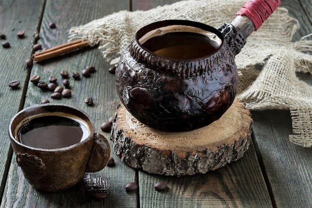 Café caliente en vajilla de barro sobre una mesa de madera. estilo vintage, enfoque selectivo