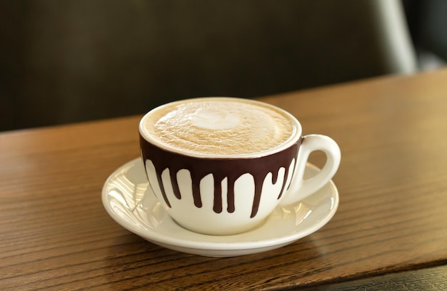 Café cappuccino em xícara de cerâmica na mesa de madeira
