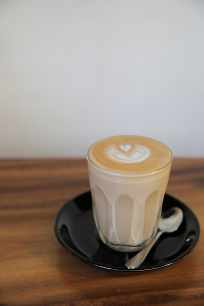 Café cappuccino ou latte art feito de leite na mesa de madeira na cafeteria