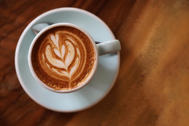 Café cappuccino ou latte art feito de leite na mesa de madeira na cafeteria