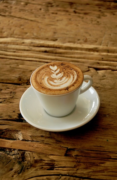 café cappuchino quente na mesa de madeira