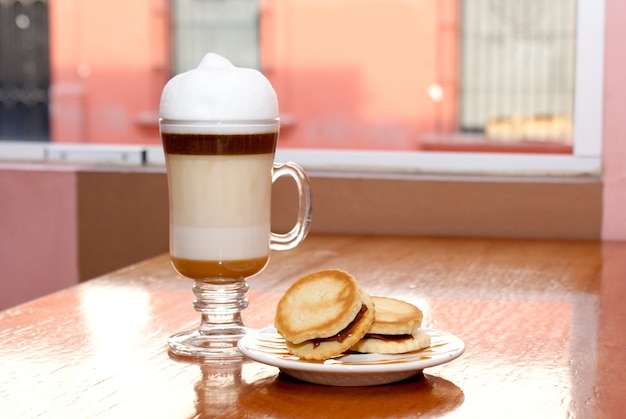 Café capuchino con un par de galletas