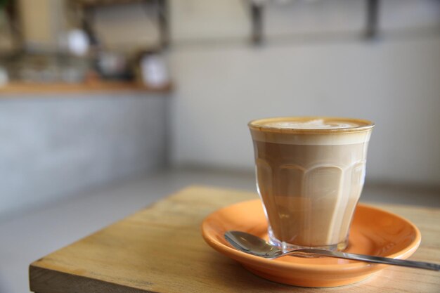 Café capuchino sobre fondo de madera en la cafetería.