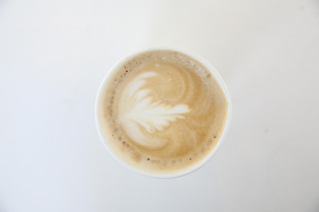 Café capuchino en taza de papel de café en coffeeshop de tono blanco