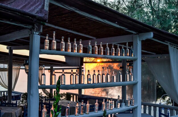 Café cerca del mar de tablones ásperos con muchas botellas Al atardecer o al amanecer