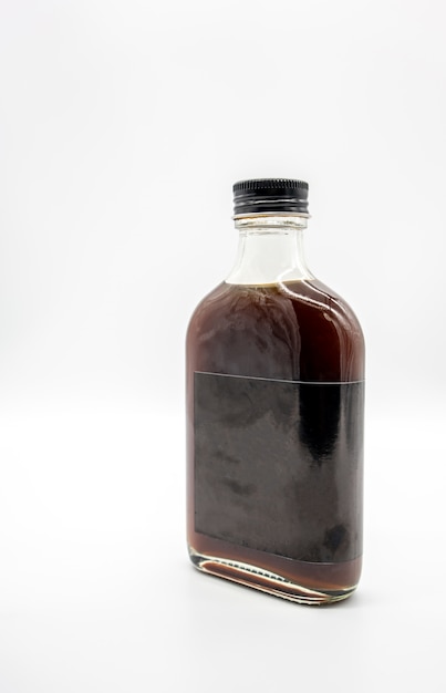 Foto café cold brew en botella de vidrio con tapa negra aislado en blanco