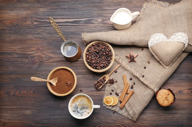 Café com feijão e especiarias na mesa de madeira