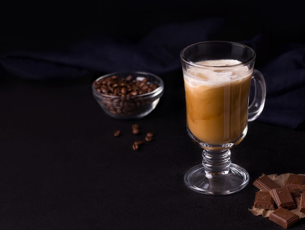 Café com gelo, caramelo e creme em um fundo preto