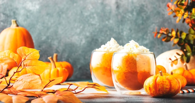 Café com leite de abóbora com creme de limpeza em copos de vidro na mesa cinza Bebida quente de outono ou inverno em mesa festiva