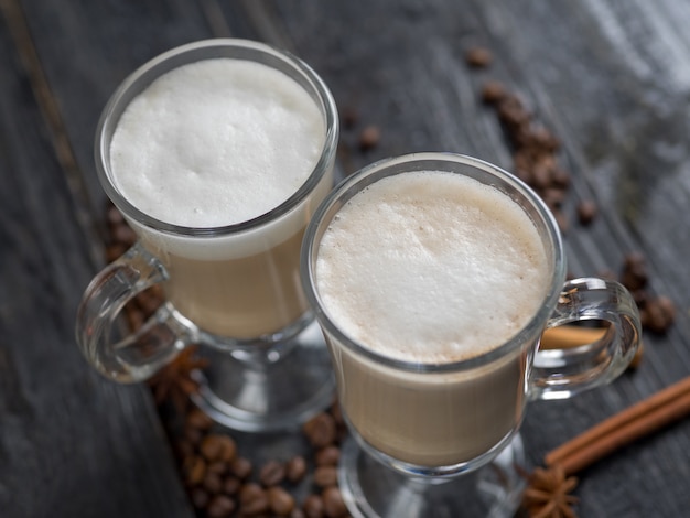 Café com leite em um copo no fundo escuro de madeira