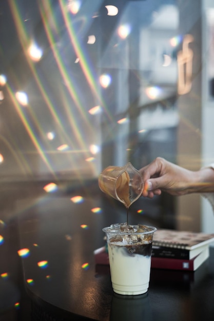 Café com leite gelado em copo de plástico na mesa preta do café