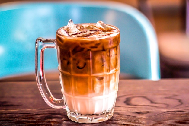 Café com leite gelado em um copo com creme no fundo da bebida fria de verão