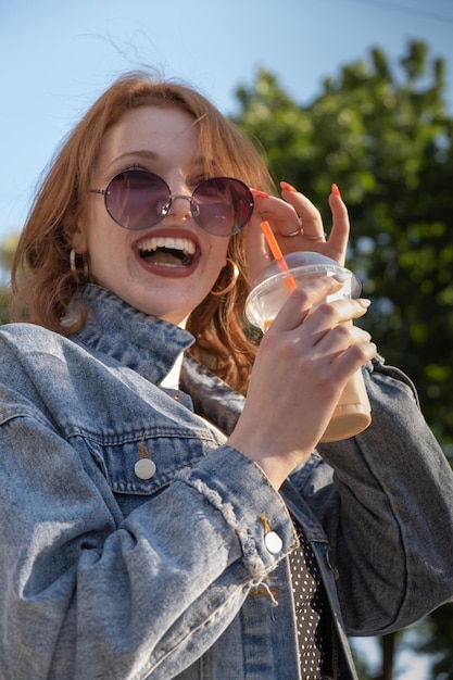 Café com leite gelado para ir na mão feminina ao ar livre