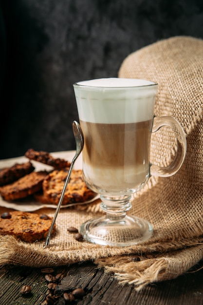 Café com leite Macchiato com biscoitos na mesa de madeira