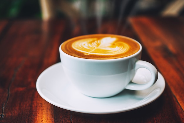 Foto café com leite na mesa de madeira na cafeteria