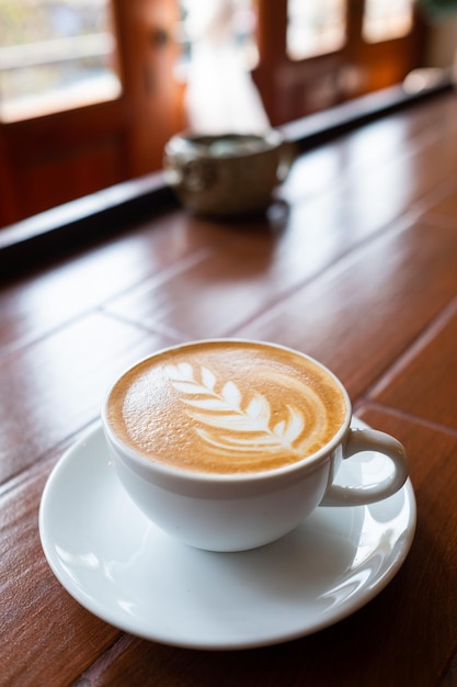 Café com leite quente na mesa de madeira relaxa o tempo