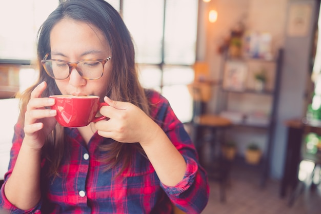 Foto café de consumición de la muchacha asiática del adolescente en café de la cafetería.