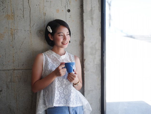 Café de consumición de la mujer asiática en café