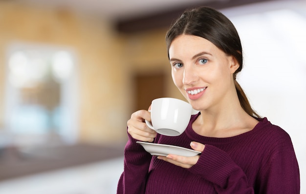 Café de consumición del retrato joven y hermoso de la mujer