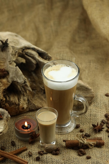 Café de cristal con copa de licor de crema irlandesa y especias Fondo de tela con espacio de copia