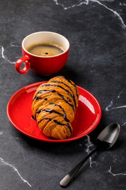 Café con croissant de chocolate. Desayuno.