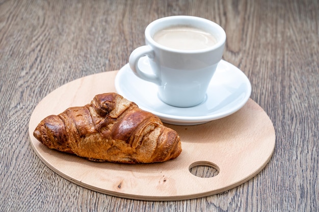 Café y croissant para desayunar en la cafetería.