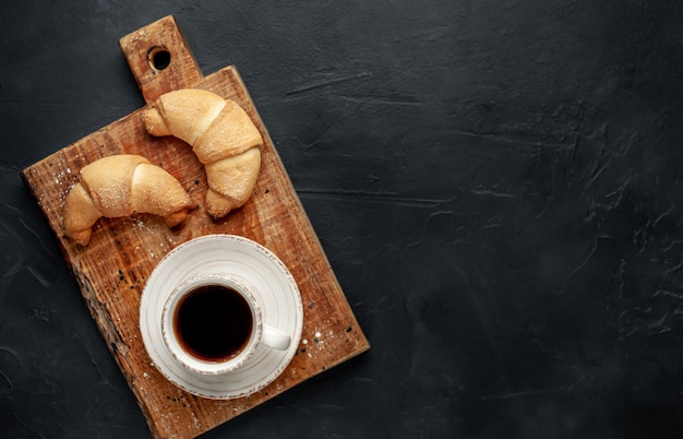 Café y croissants sobre un fondo de piedra. delicioso desayuno con copia espacio para su texto