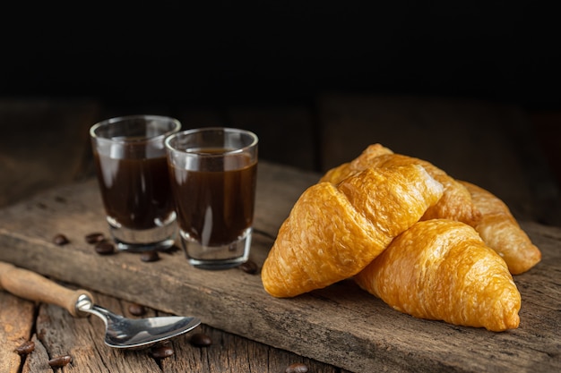 Café y croissants en la superficie de madera