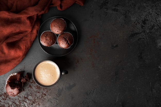 Café con cupcakes de chocolate sobre un fondo oscuro. café con muffins de chocolate con relleno de grosellas. foto de alta calidad