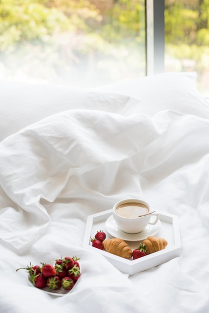Café da manhã aconchegante na cama xícara de café e croissants