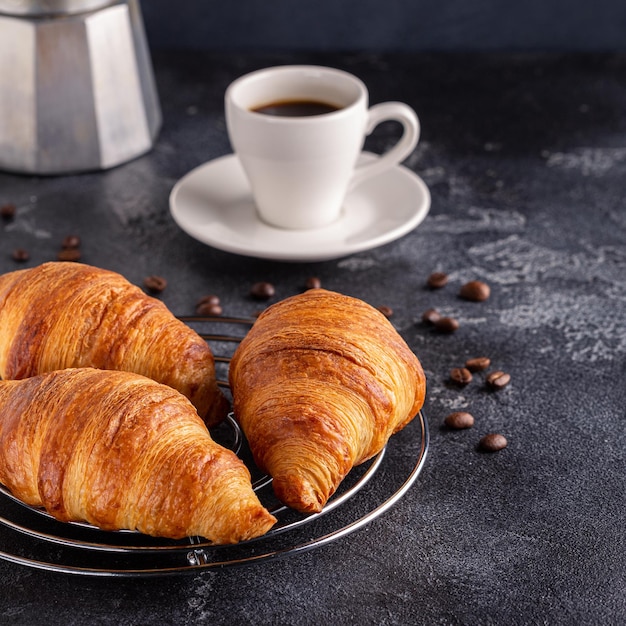 Café da manhã com café e croissants, foco seletivo