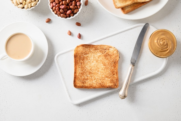 Café da manhã com café e torrada crocante com pasta de amendoim.