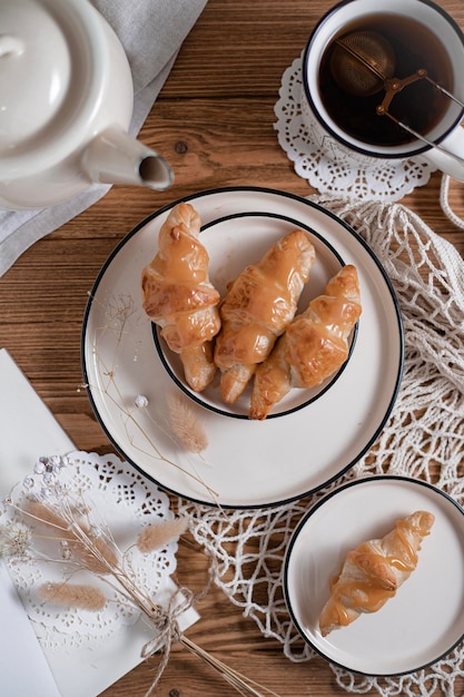 Café da manhã com chá e croissants na mesa