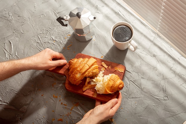 Café da manhã com croissant na tábua e café preto